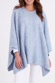Model Madeline wearing the Marnie Cable Knit Poncho in colour Iceblue (Blue), from the front, cropped image