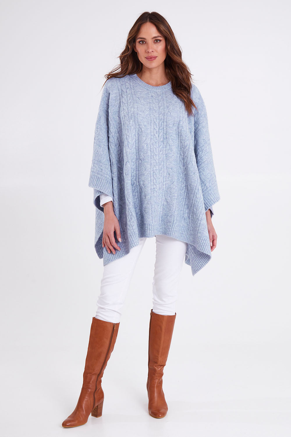 Model Madeline wearing the Marnie Cable Knit Poncho in colour Iceblue (Blue), from the front, showing the whole outfit