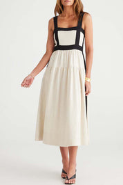 A model wearing the Jolie Dress in colour Naturalblk, from the front, cropped image