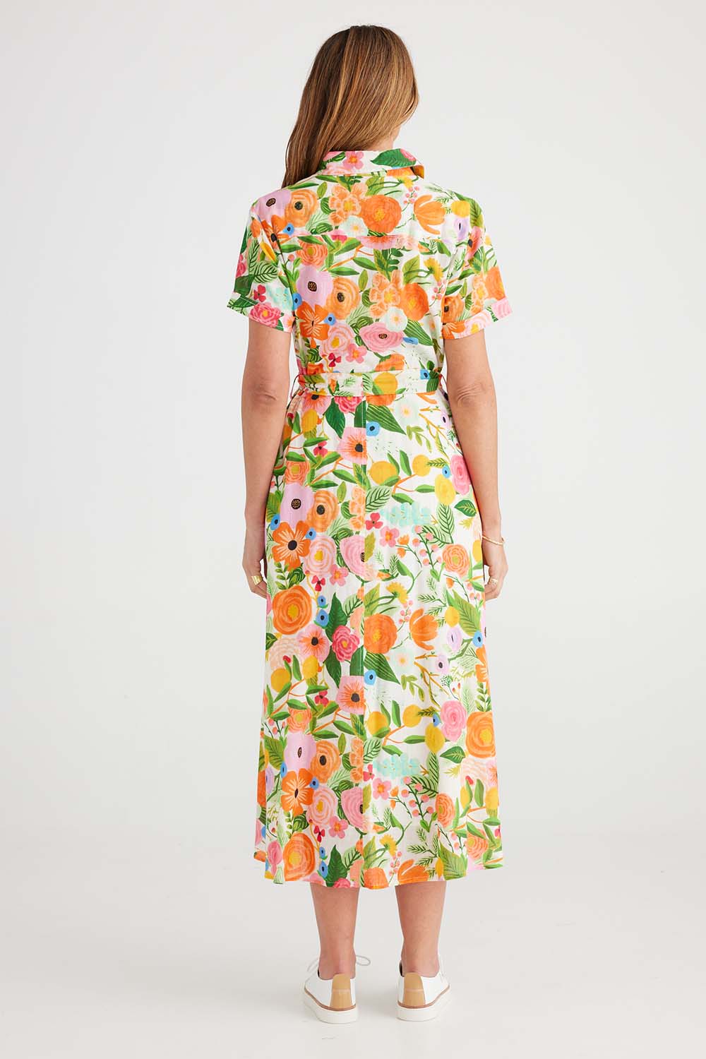 A model wearing the Rosselini Dress in colour Blossom (Green), from the back