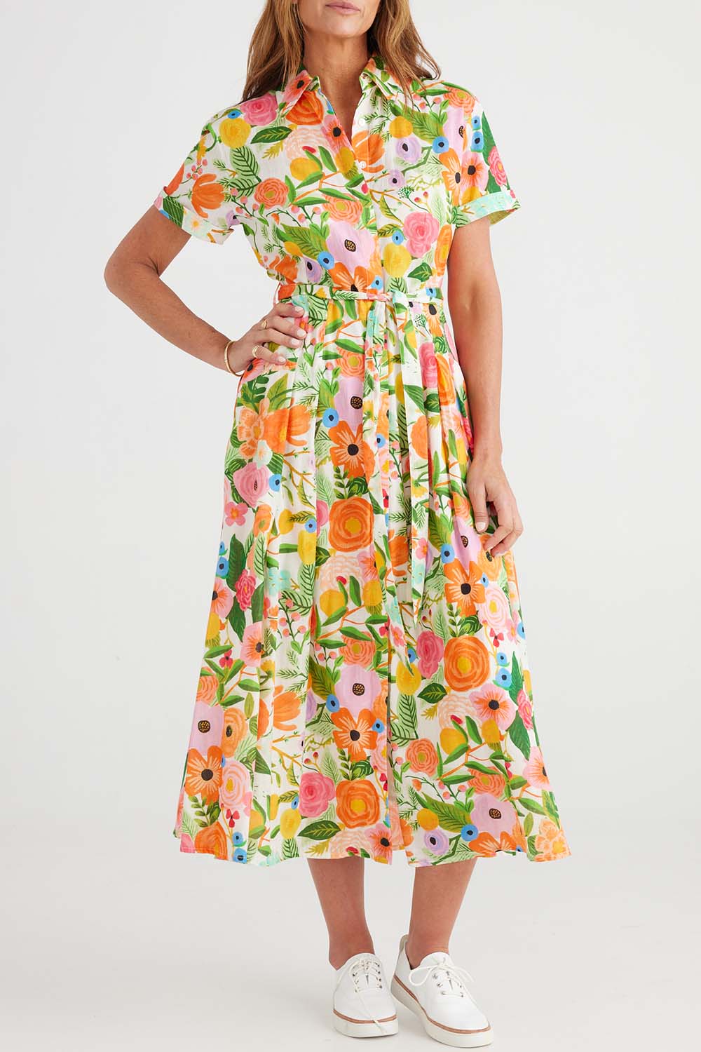 A model wearing the Rosselini Dress in colour Blossom (Green), from the front, cropped image
