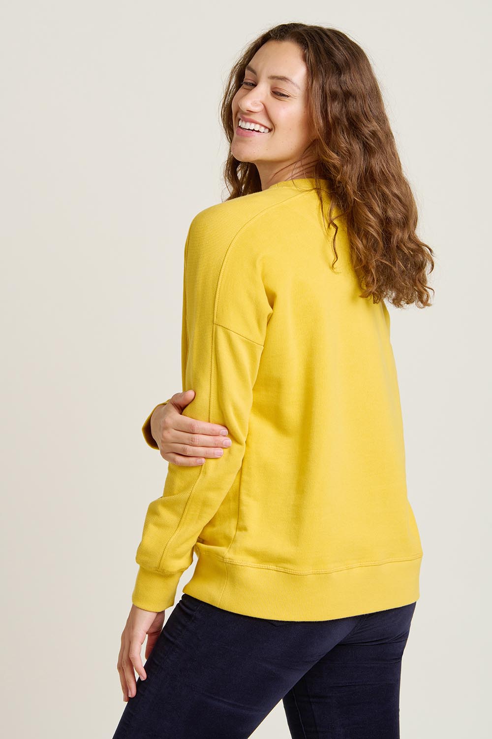 A model wearing the Star Crew Neck Cotton Sweatshirt in colour Mustard, from the back