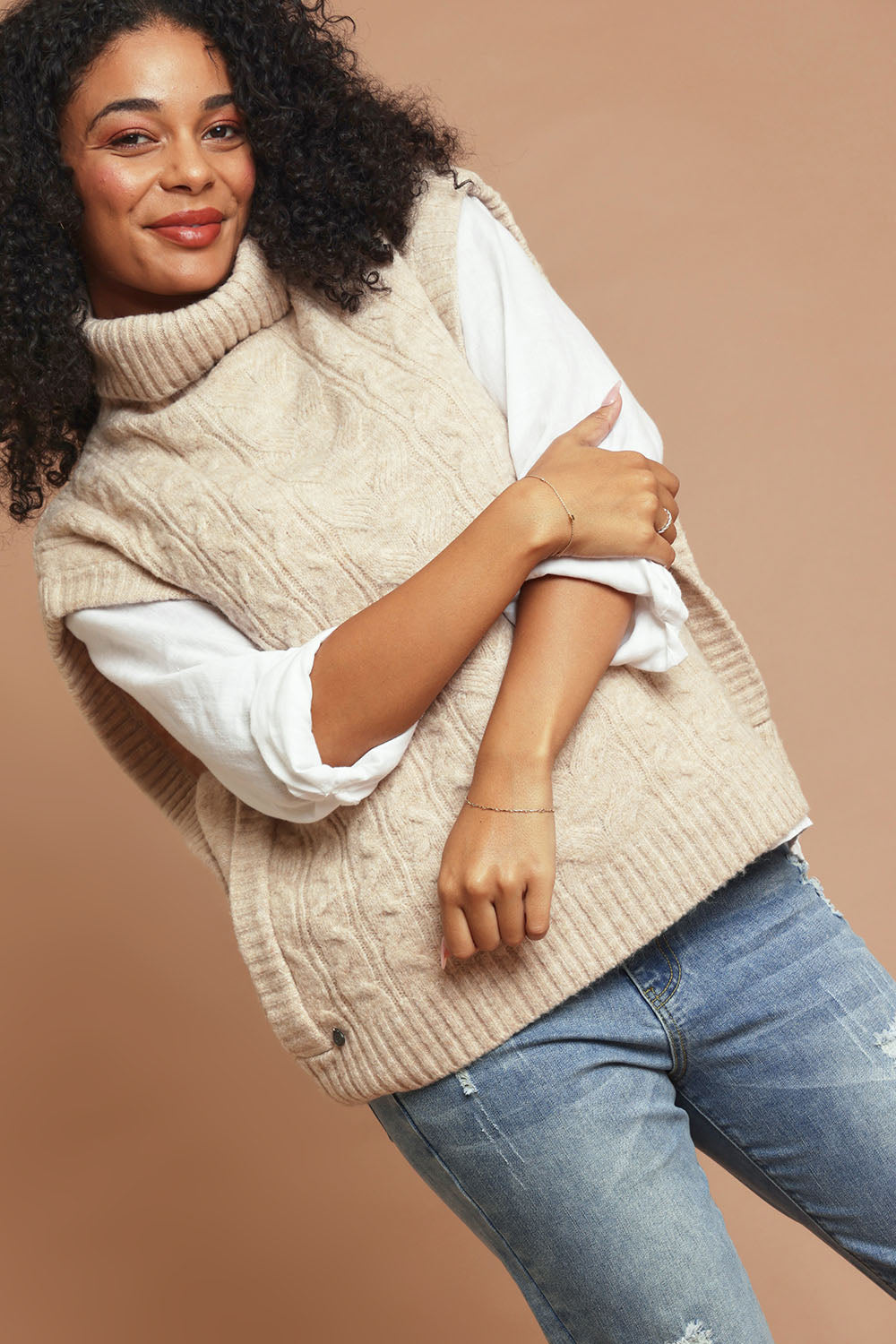 Model Ziara wearing size 10 of the Cable Knitted Vest in colour Natural, from the front, showing the whole outfit