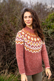 A model wearing the Chunky Knitted Fair Isle Jumper in colour Rust, from the front, showing the whole outfit