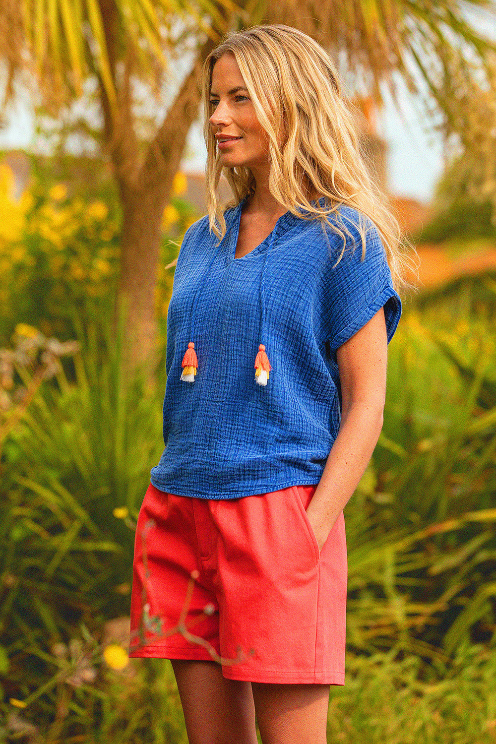 A model wearing the Red Cotton Beach Short in colour Red (Red), from the front, showing the whole outfit