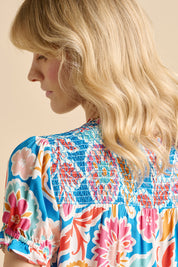 A model wearing the Full Bloom Blouse in colour Multi (Blue), from the back
