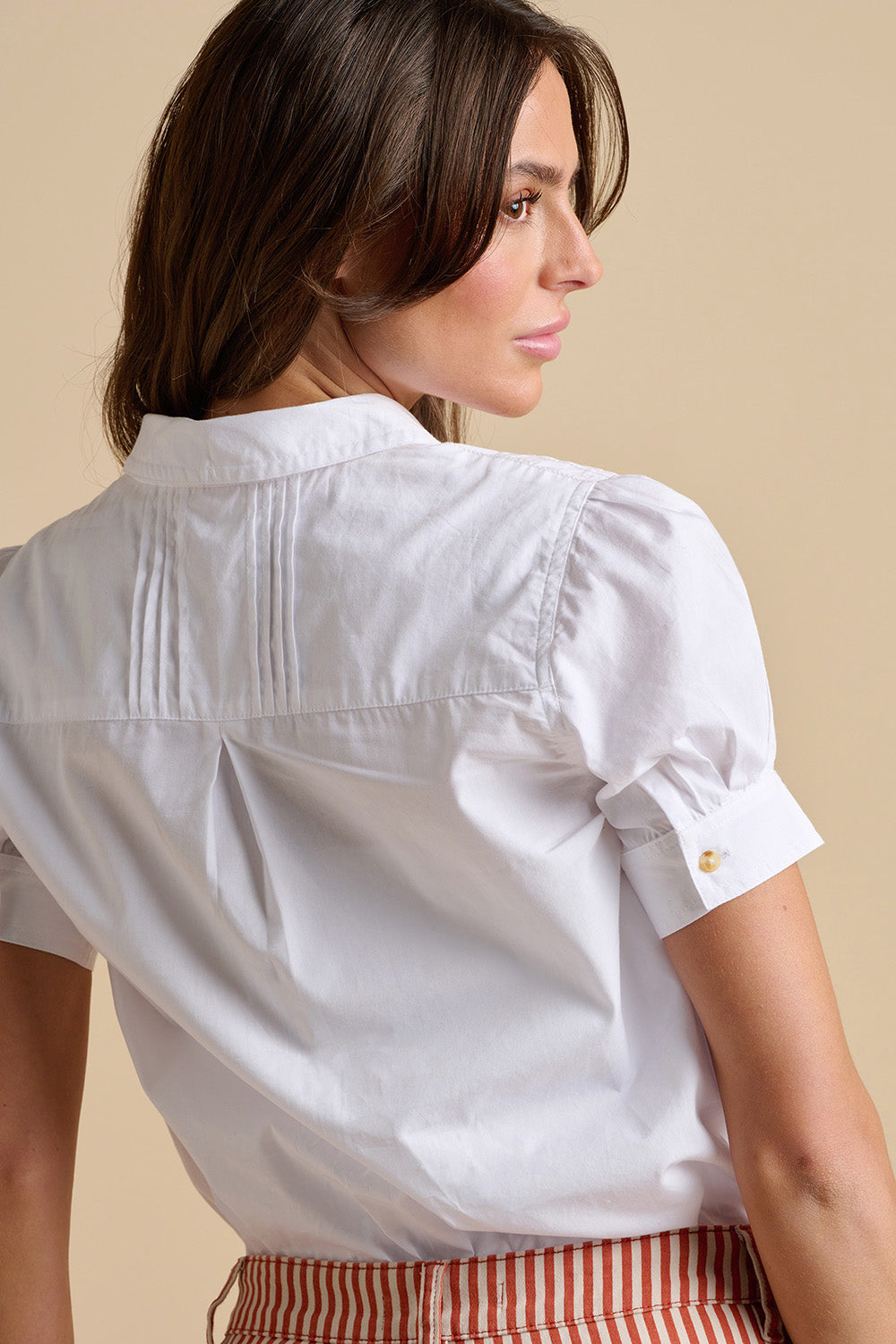 A model wearing the Cowrie Cotton Blouse in colour White (White), from the back