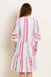A model wearing the Nessa Dress in colour Multi (Pink), from the back