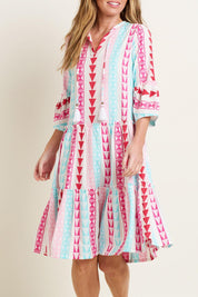A model wearing the Nessa Dress in colour Multi (Pink), from the front, cropped image