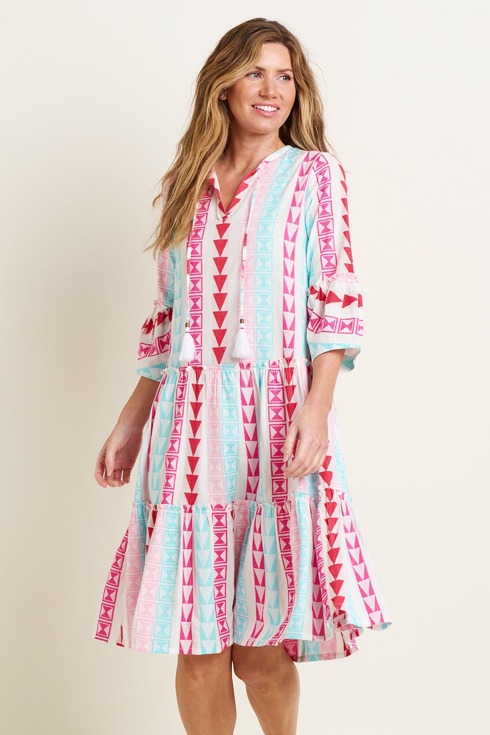 A model wearing the Nessa Dress in colour Multi (Pink), from the front, cropped image