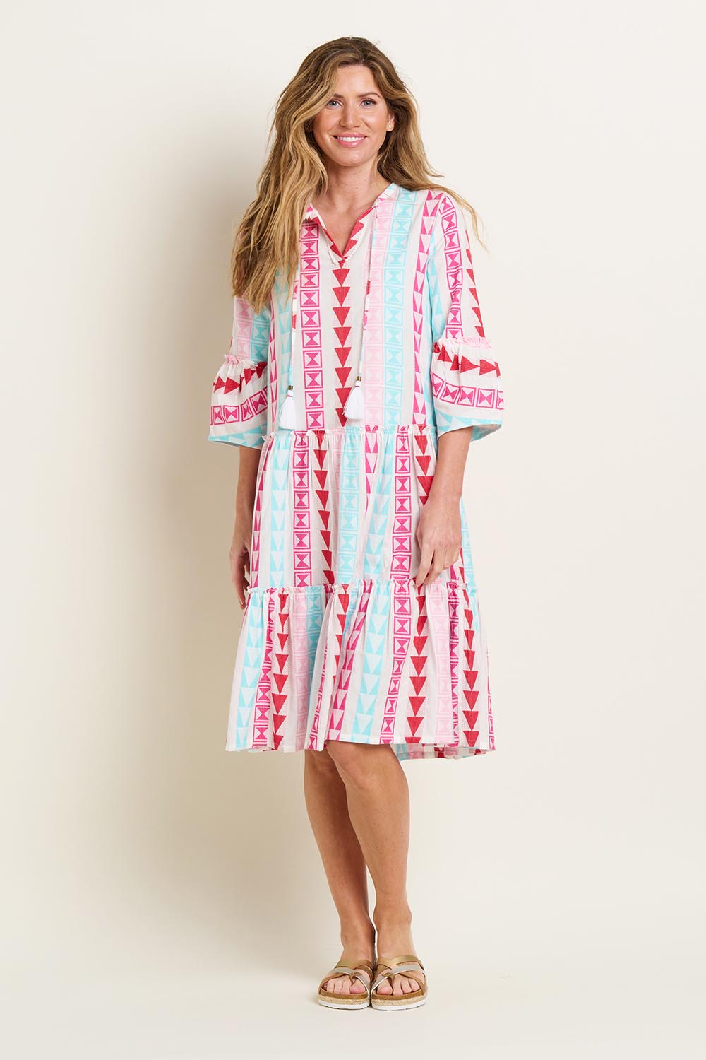 A model wearing the Nessa Dress in colour Multi (Pink), from the front, showing the whole outfit