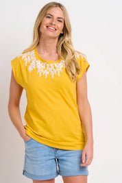 A model wearing the Zoe Tee in colour Yellow, from the front, cropped image