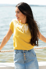 A model wearing the Zoe Tee in colour Yellow, from the front, showing the whole outfit