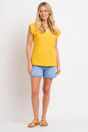 A model wearing the Zoe Tee in colour Yellow, from the front, showing the whole outfit