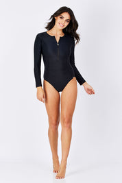 Model Monika wearing size 10 of the Zip Front Long Sleeve One Piece in colour Black (Black), from the front, showing the whole outfit