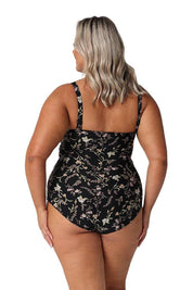 A model wearing the Twist Front Bandeau One Piece in colour Wildflower (Black), from the back
