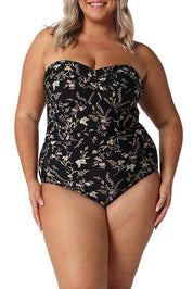A model wearing the Twist Front Bandeau One Piece in colour Wildflower (Black), from the front, cropped image