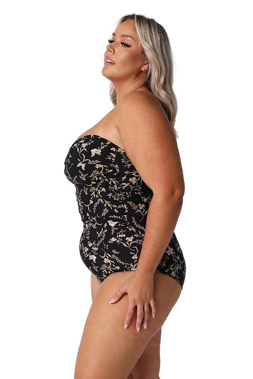 A model wearing the Twist Front Bandeau One Piece in colour Wildflower (Black), from the front, cropped image