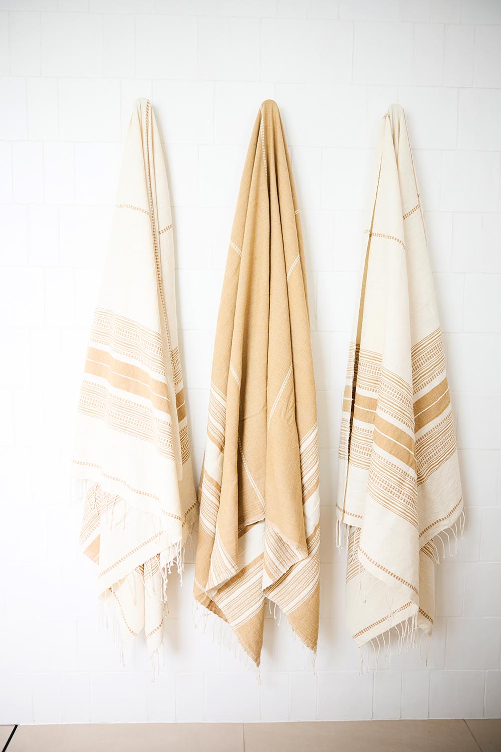 A model wearing size OneSize of the Handwoven Genale Bath Towel in colour Butterscth, from the front, showing the whole outfit