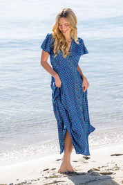 A model wearing the Pirrin Silk Blend Wrap Dress in colour Pirrin (Blue), from the front, showing the whole outfit