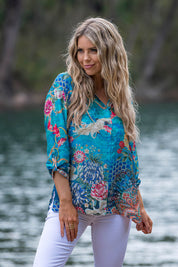 A model wearing the Floral Crane Shirt in colour Crane (Blue), from the front, showing the whole outfit