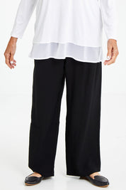 Model Elise wearing size S of the Wide Leg Relaxed Pant in colour Black (Black), from the front, cropped image