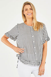 Model Kelly wearing size S of the Check Frill Hem Top in colour Black (Black), from the front, cropped image