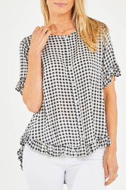 Model Kelly wearing size S of the Check Frill Hem Top in colour Black (Black), from the front, cropped image