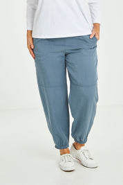 Model Laura wearing size L of the Lyocell Pant in colour Slate (Grey), from the front, cropped image