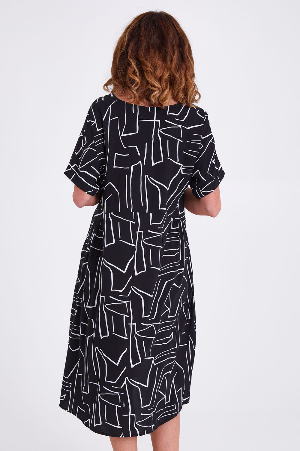 Model Emma wearing size S of the Empire Dress in colour Black (Black), from the back