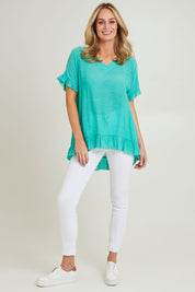 Model Grace wearing size S of the Button Back Top in colour Spearmint (Green), from the front, showing the whole outfit