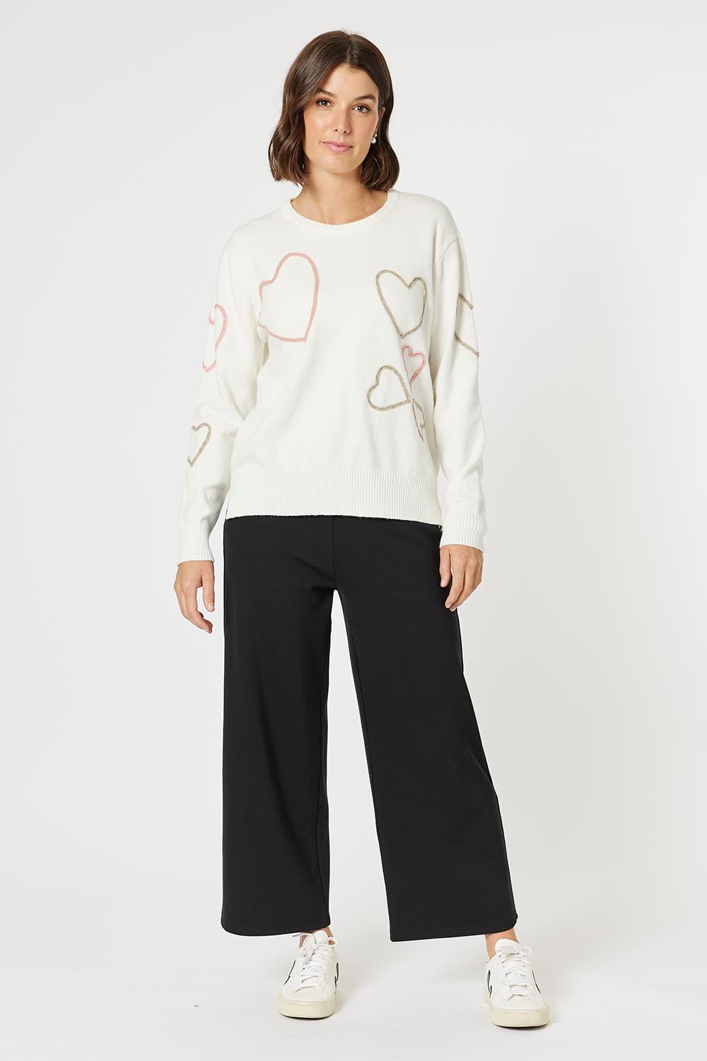 A model wearing the Love Me Knit Jumper in colour Ivory, from the front, showing the whole outfit