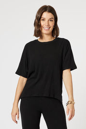 A model wearing the Lounge Top in colour Black (Black), from the front, cropped image