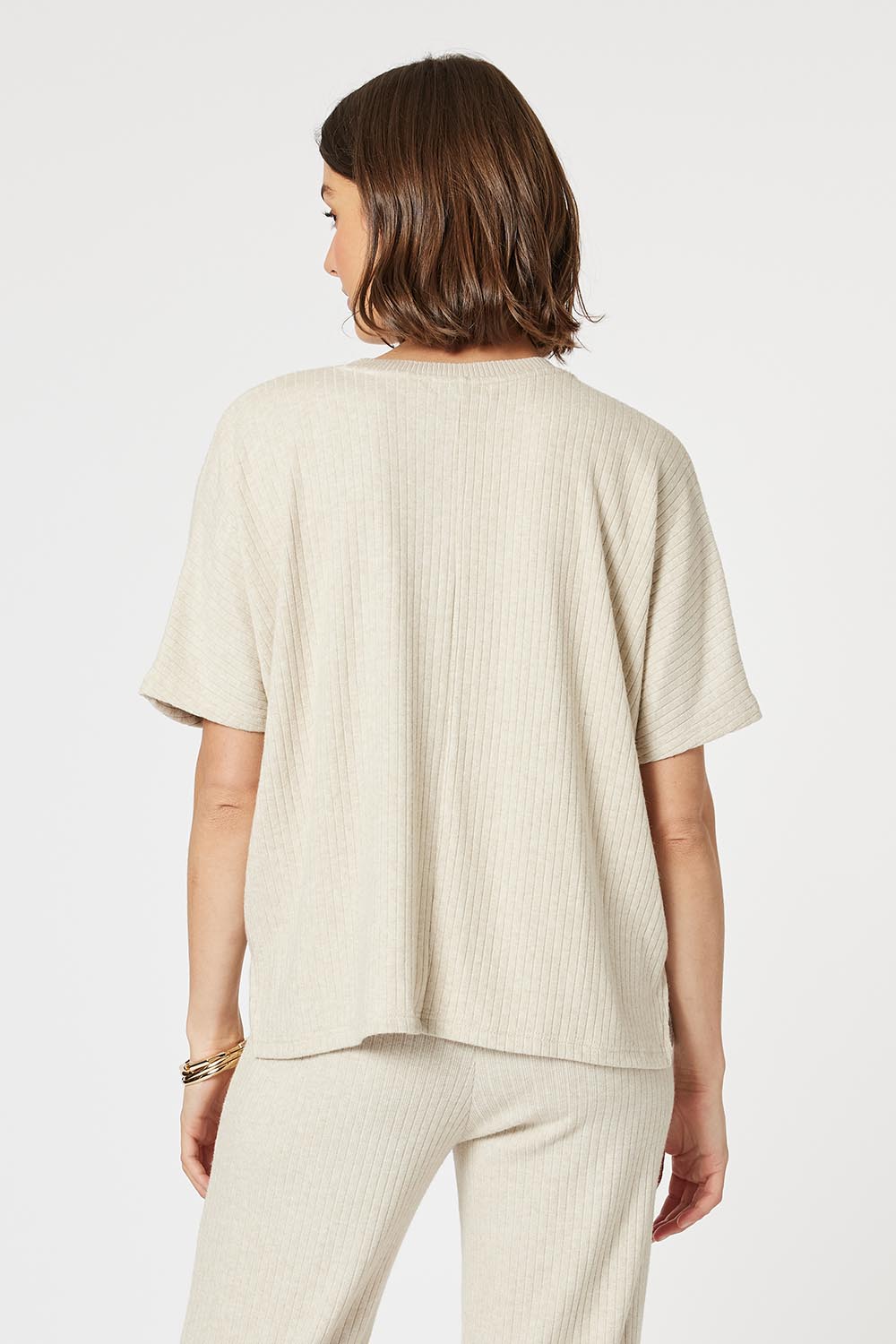 A model wearing the Lounge Top in colour Natural, from the back
