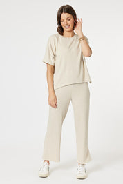 A model wearing the Lounge Top in colour Natural, from the front, showing the whole outfit