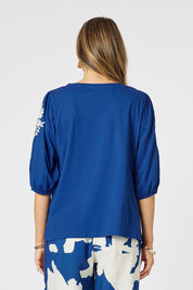 A model wearing the Jill Embroidered Cotton Tee in colour Blue (Blue), from the back