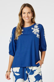 A model wearing the Jill Embroidered Cotton Tee in colour Blue (Blue), from the front, cropped image