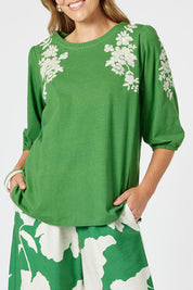 A model wearing the Jill Embroidered Cotton Tee in colour Elm (Green), from the front, cropped image