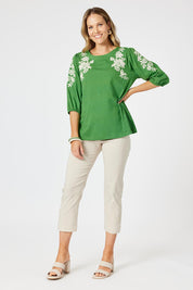 A model wearing the Jill Embroidered Cotton Tee in colour Elm (Green), from the front, showing the whole outfit