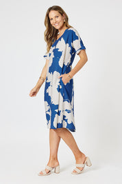 A model wearing the Barcelona Dress in colour Blue (Blue), from the front, showing the whole outfit