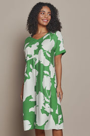 Model Ziara wearing size S of the Barcelona Dress in colour Elm (Green), from the front, cropped image