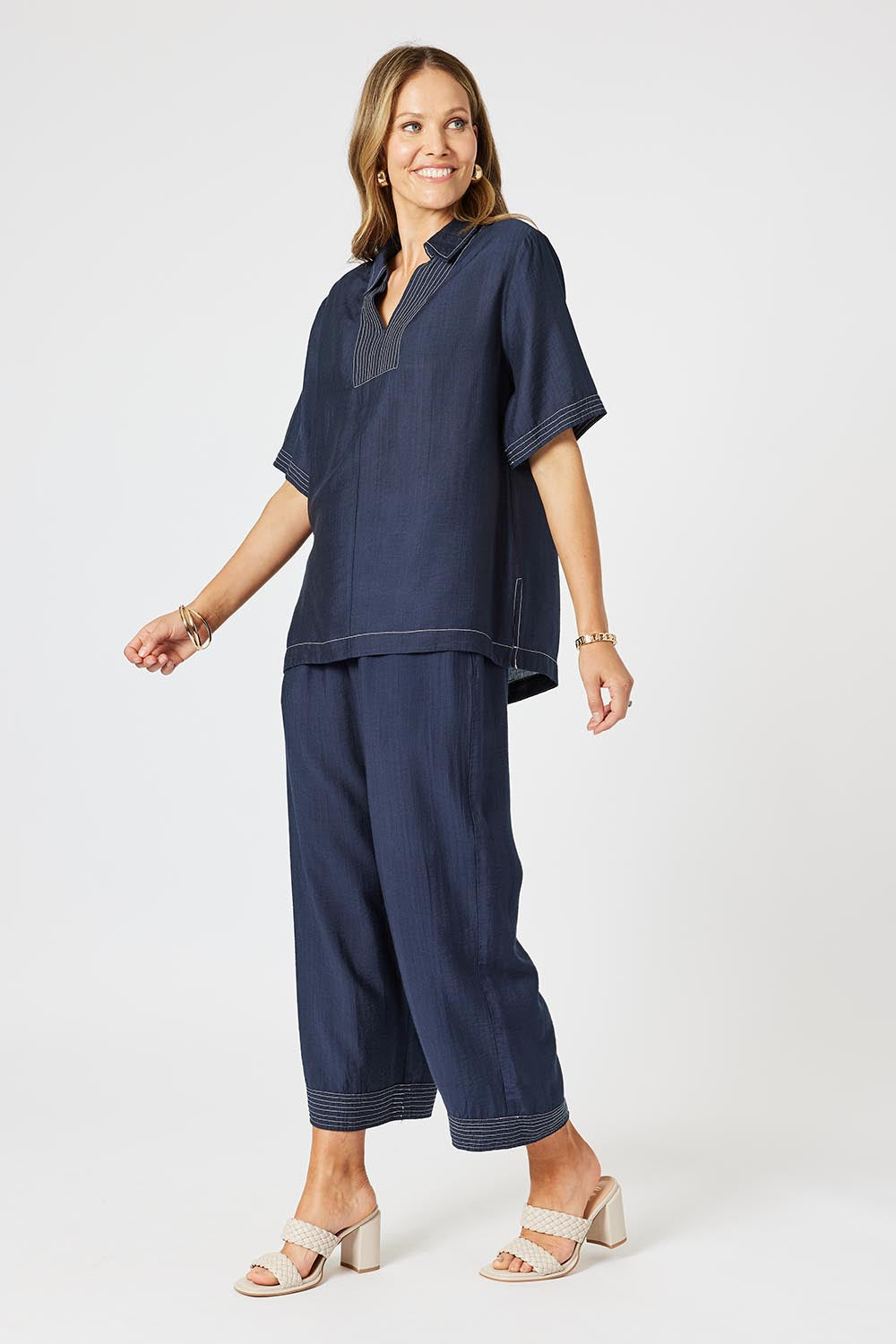 A model wearing the Top Stitch Top in colour Navy (Blue), from the front, showing the whole outfit