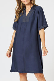 A model wearing the Top Stitch Dress in colour Navy (Blue), from the front, cropped image