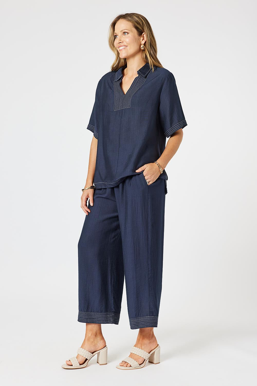 A model wearing the Top Stitch Pant in colour Navy (Blue), from the front, showing the whole outfit