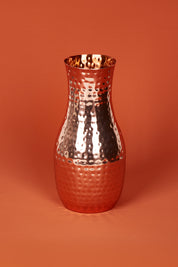 A model wearing size OneSize of the Boxed Hammered Copper Carafe in colour Copper (Metallics), from the front, showing the whole outfit