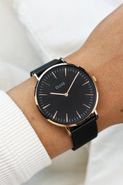 A model wearing the Chic Black Rose Gold Watch in colour Blackrose (Black), from the front, cropped image