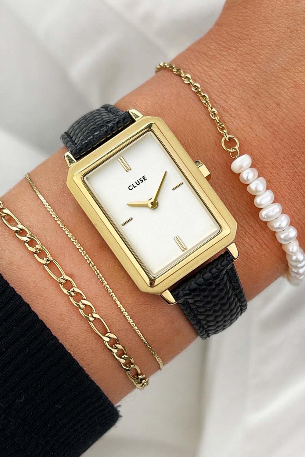 A model wearing the Fluette Black Leather Watch in colour Blackgold (Black), from the front, cropped image