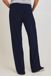 Model Madeline wearing size 10 of the Travel Wide Leg Pant in colour Navy (Blue), from the back