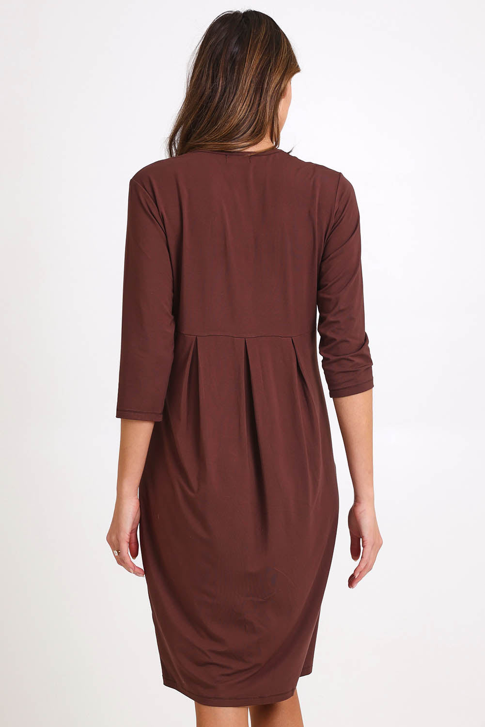 Model Madelinec wearing size 10 of the Box Pleat Dress – Choc in colour Choc, from the back