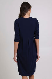 Model Madeline wearing size 10 of the Box Pleat Dress in colour Navy (Blue), from the back